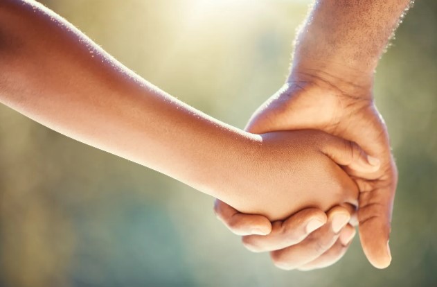 Adulto y niño tomados de la mano